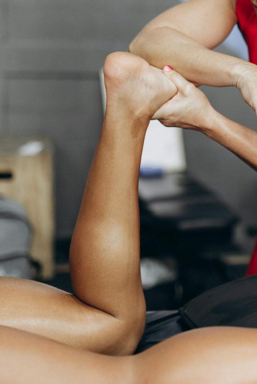 A physical therapist assists a patient with leg rehabilitation at a clinic.